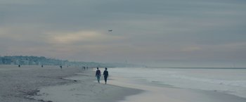 Movie still from “Endings, Beginnings” (2019), directed by Drake Doremus – Two people walking on the beach near the ocean; Extreme Wide shot, Low angle