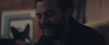 Movie still from “Endings, Beginnings” (2019), directed by Drake Doremus – A man with a goatee smiling for the camera; Close Up shot, Over the shoulder angle