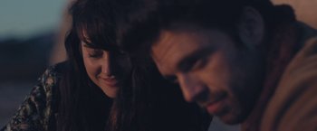Movie still from “Endings, Beginnings” (2019), directed by Drake Doremus – A man and a woman smiling at each other in the dark; Close Up shot, Over the shoulder angle