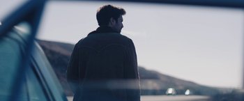 Movie still from “Endings, Beginnings” (2019), directed by Drake Doremus – A man in a brown jacket is looking out a window; Close Up shot, Over the shoulder angle