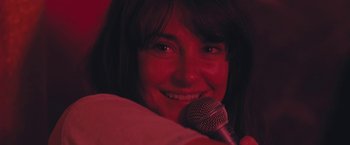 Movie still from “Endings, Beginnings” (2019), directed by Drake Doremus – A person holding a microphone; Close Up shot, Over the shoulder angle
