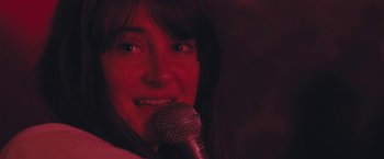 Movie still from “Endings, Beginnings” (2019), directed by Drake Doremus – A person holding a microphone; Close Up shot, Over the shoulder angle