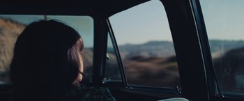 Movie still from “Endings, Beginnings” (2019), directed by Drake Doremus – A woman sitting in the passenger seat of a car looking out the window; Close Up shot, High angle