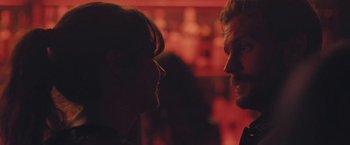 Movie still from “Endings, Beginnings” (2019), directed by Drake Doremus – A man and a woman face to face in front of a red background; Close Up shot, Over the shoulder angle