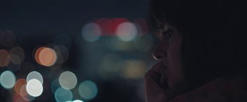Movie still from “Endings, Beginnings” (2019), directed by Drake Doremus – A woman with her hand to her face looking into the distance; Extreme Close Up shot, Low angle
