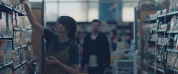 Movie still from “Endings, Beginnings” (2019), directed by Drake Doremus – A woman standing next to a man in front of a store; Medium shot, Over the shoulder angle