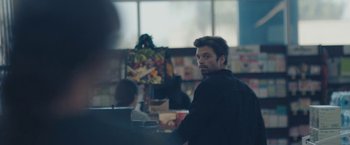 Movie still from “Endings, Beginnings” (2019), directed by Drake Doremus – A man in a black jacket is sitting in front of a window; Medium shot, Over the shoulder angle