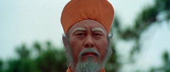 Movie still from “Enter the Dragon” (1973), directed by Robert Clouse – An old man with a beard and a hat; Close Up shot, Low angle