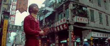 Movie still from “Enter the Dragon” (1973), directed by Robert Clouse – A man standing on the street in front of a building; Medium shot, Low angle