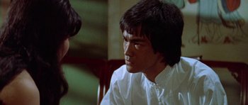 Movie still from “Enter the Dragon” (1973), directed by Robert Clouse – A man sitting in front of a wooden chair; Close Up shot, Over the shoulder angle