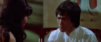 Movie still from “Enter the Dragon” (1973), directed by Robert Clouse – A man in white shirt sitting in front of another man; Close Up shot, Over the shoulder angle