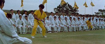 Movie still from “Enter the Dragon” (1973), directed by Robert Clouse – A group of men in white suits and yellow shirts; Wide shot, Low angle