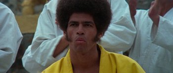 Movie still from “Enter the Dragon” (1973), directed by Robert Clouse – A person wearing a yellow robe; Close Up shot, Low angle