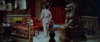Movie still from “Enter the Dragon” (1973), directed by Robert Clouse – A man in a robe walking in a room with statues; Wide shot, High angle