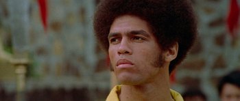 Movie still from “Enter the Dragon” (1973), directed by Robert Clouse – A person wearing a yellow shirt; Close Up shot, Low angle