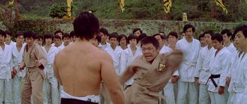Movie still from “Enter the Dragon” (1973), directed by Robert Clouse – A group of men standing in front of each other; Medium shot, Over the shoulder angle