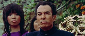 Movie still from “Enter the Dragon” (1973), directed by Robert Clouse – An older man with long hair and a goatee looks at the camera; Close Up shot, Low angle