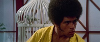 Movie still from “Enter the Dragon” (1973), directed by Robert Clouse – A person wearing a yellow shirt; Close Up shot, Low angle