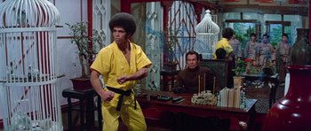 Movie still from “Enter the Dragon” (1973), directed by Robert Clouse – A man in a yellow shirt and a man in a brown shirt; Medium shot, Low angle