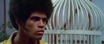 Movie still from “Enter the Dragon” (1973), directed by Robert Clouse – A person wearing a yellow shirt; Close Up shot, Low angle