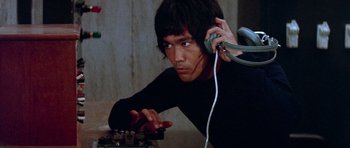 Movie still from “Enter the Dragon” (1973), directed by Robert Clouse – A young man is listening to music on his headphones; Close Up shot, Low angle