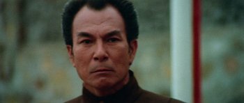 Movie still from “Enter the Dragon” (1973), directed by Robert Clouse – An older man with a serious look on his face; Close Up shot, Low angle