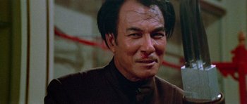 Movie still from “Enter the Dragon” (1973), directed by Robert Clouse – A person wearing a brown shirt; Close Up shot, Low angle