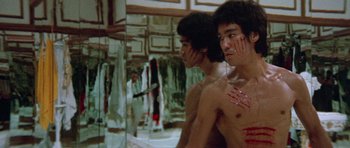 Movie still from “Enter the Dragon” (1973), directed by Robert Clouse – Two young men are looking in the mirror; Medium shot, Low angle