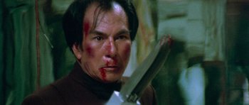 Movie still from “Enter the Dragon” (1973), directed by Robert Clouse – A person holding a knife with blood all over his face; Close Up shot, Low angle
