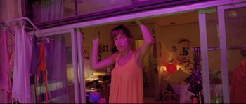 Movie still from “Enter the Void” (2009), directed by Gaspar Noé – A woman standing in front of an open door; Medium shot, Low angle