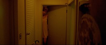 Movie still from “Enter the Void” (2009), directed by Gaspar Noé – A woman standing in the doorway of a room; Medium shot, High angle