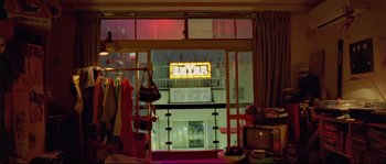 Movie still from “Enter the Void” (2009), directed by Gaspar Noé – A room that has a lot of clothes on it; Wide shot, High angle