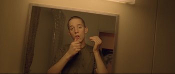 Movie still from “Enter the Void” (2009), directed by Gaspar Noé – A man brushing his teeth in a bathroom mirror; Close Up shot, Low angle