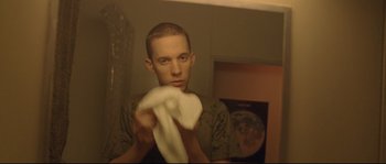 Movie still from “Enter the Void” (2009), directed by Gaspar Noé – A man holding a towel in front of a bathroom mirror; Close Up shot, Low angle