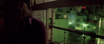 Movie still from “Enter the Void” (2009), directed by Gaspar Noé – A man standing in front of a large window; Medium shot, Low angle
