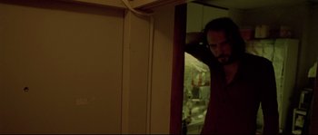 Movie still from “Enter the Void” (2009), directed by Gaspar Noé – A man standing in front of a mirror in a room; Medium shot, Low angle