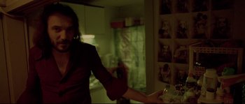 Movie still from “Enter the Void” (2009), directed by Gaspar Noé – A woman in a dark kitchen holding a knife; Medium shot, Low angle