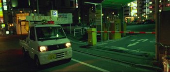 Movie still from “Enter the Void” (2009), directed by Gaspar Noé – A white van driving down a street at night; Wide shot, High angle
