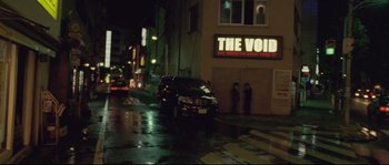 Movie still from “Enter the Void” (2009), directed by Gaspar Noé – A car parked on the side of the street at night; Extreme Wide shot, High angle