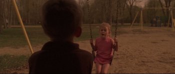 Movie still from “Enter the Void” (2009), directed by Gaspar Noé – A little boy and a little girl on a swing; Wide shot, High angle