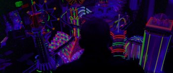 Movie still from “Enter the Void” (2009), directed by Gaspar Noé – A man standing in front of a wall of neon lights; Extreme Wide shot, High angle
