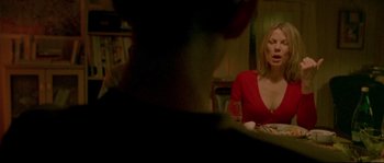 Movie still from “Enter the Void” (2009), directed by Gaspar Noé – A woman sitting at a table with a glass of red wine; Medium shot, Over the shoulder angle