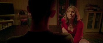 Movie still from “Enter the Void” (2009), directed by Gaspar Noé – A woman sitting on a couch next to a young man; Medium shot, Over the shoulder angle