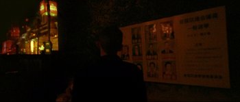 Movie still from “Enter the Void” (2009), directed by Gaspar Noé – A man standing in front of a wall of pictures; Close Up shot, Over the shoulder angle