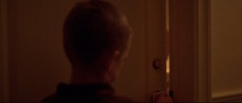 Movie still from “Enter the Void” (2009), directed by Gaspar Noé – A young boy standing in front of a door; Close Up shot, Over the shoulder angle