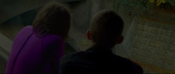 Movie still from “Enter the Void” (2009), directed by Gaspar Noé – Two children are looking out a window at a building; Medium shot, High angle