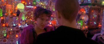 Movie still from “Enter the Void” (2009), directed by Gaspar Noé – A woman is talking to a man at a party; Close Up shot, Over the shoulder angle