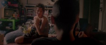 Movie still from “Enter the Void” (2009), directed by Gaspar Noé – A woman sitting next to a man on a couch; Medium shot, Over the shoulder angle