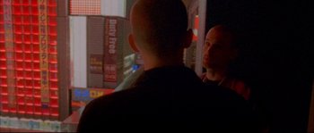 Movie still from “Enter the Void” (2009), directed by Gaspar Noé – Two men standing next to each other on a city street; Close Up shot, Over the shoulder angle