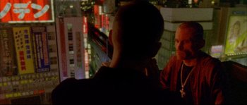 Movie still from “Enter the Void” (2009), directed by Gaspar Noé – A young boy is looking out a window at a building; Close Up shot, Over the shoulder angle